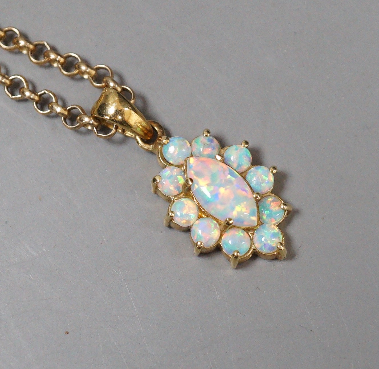 A modern 585 yellow metal and opal set oval cluster pendant, 18mm, on a 9k chain, 50cm, gross weight 9.9 grams.